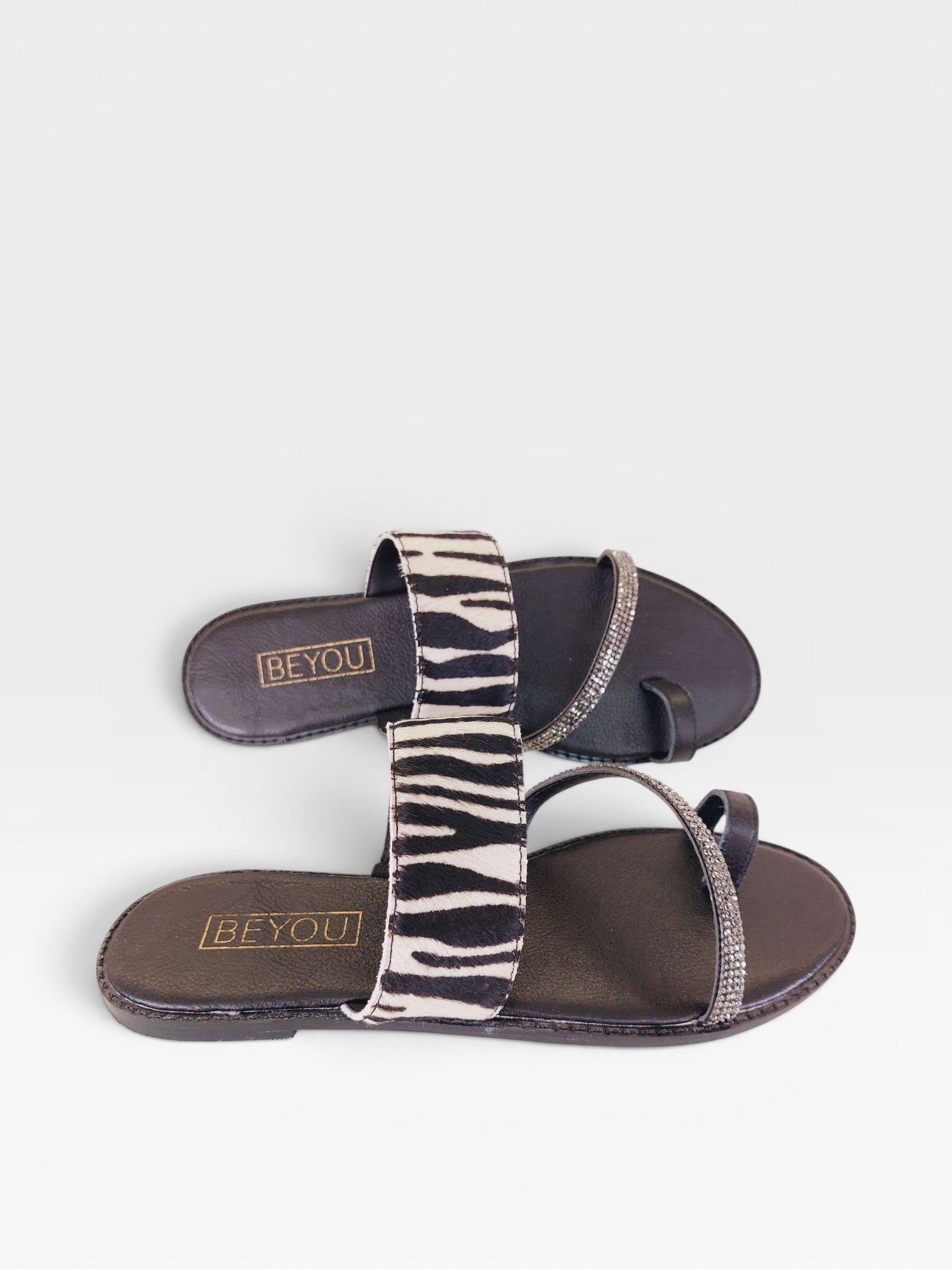 Rasteira Beyou Shoes Riad em couro com estampa de zebra e tiras decoradas com pedrarias brilhantes