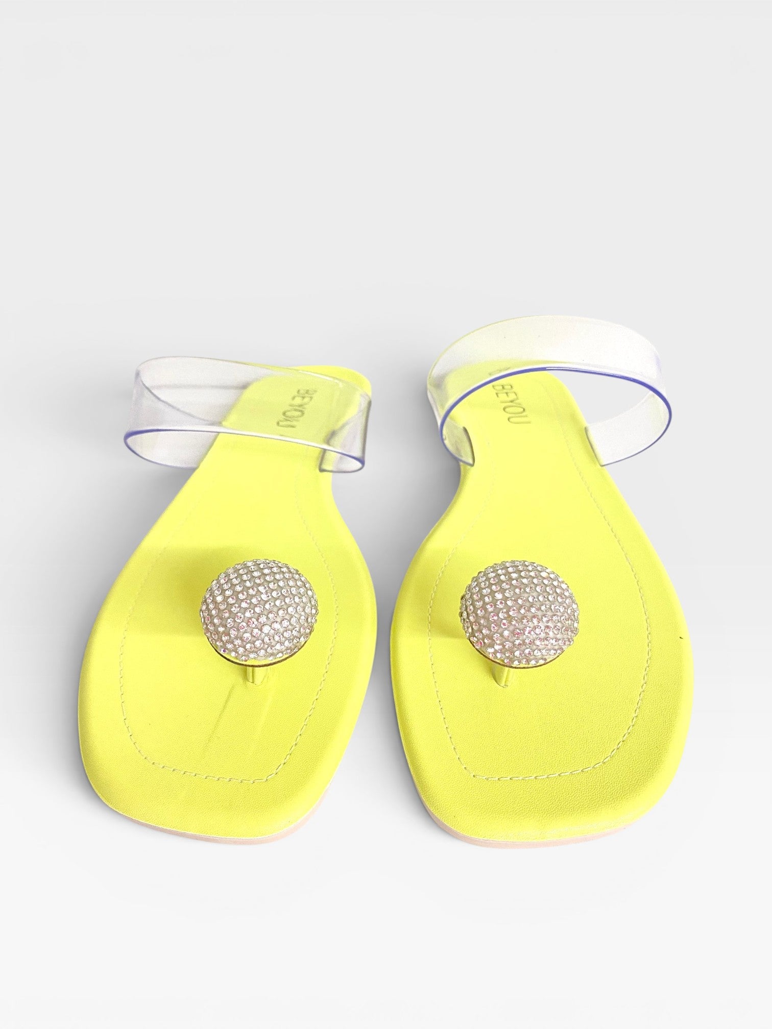 Rasteira Beyou Shoes Santorini na cor limão siciliano com tiras de vinil transparente e detalhe central de pedrarias.