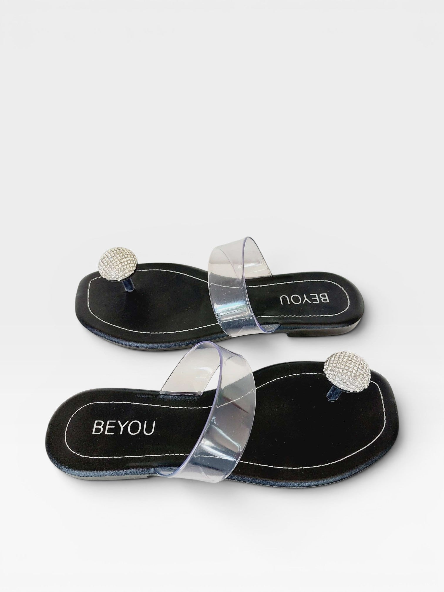 Rasteira Beyou Shoes Santorini preta em napa e vinil com tiras transparentes e detalhe de pedraria brilhante