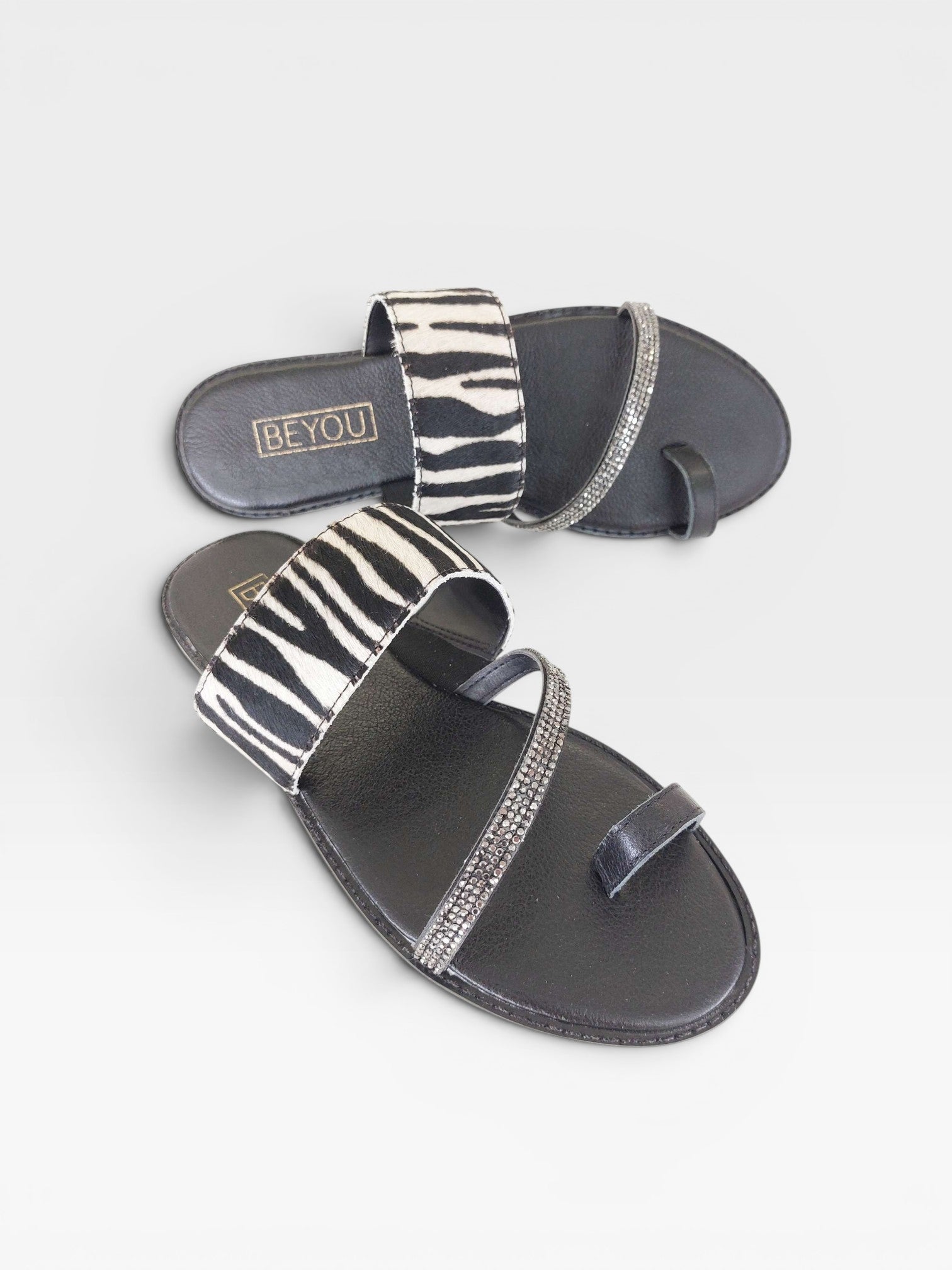 Rasteira Beyou Shoes Riad em couro com estampa de zebra e tiras decoradas com pedrarias brilhantes