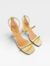 Sandália Beyou Shoes Abu Dhabi na cor ouro light, feita em tecido com tiras de brilho e salto bloco de 6 cm.