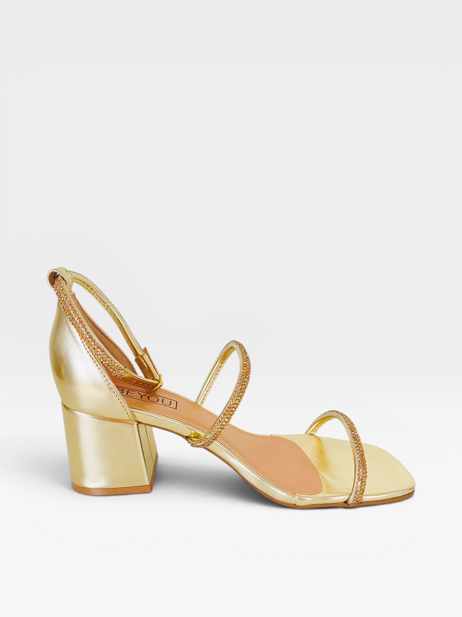 Sandália Beyou Shoes Abu Dhabi na cor ouro light, feita em tecido com tiras de strass e salto bloco de 6 cm.
