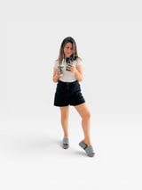 Mulher usando sandália flatform Beyou Shoes listrada em preto e branco com solado de 5 cm em uma loja de calçados.