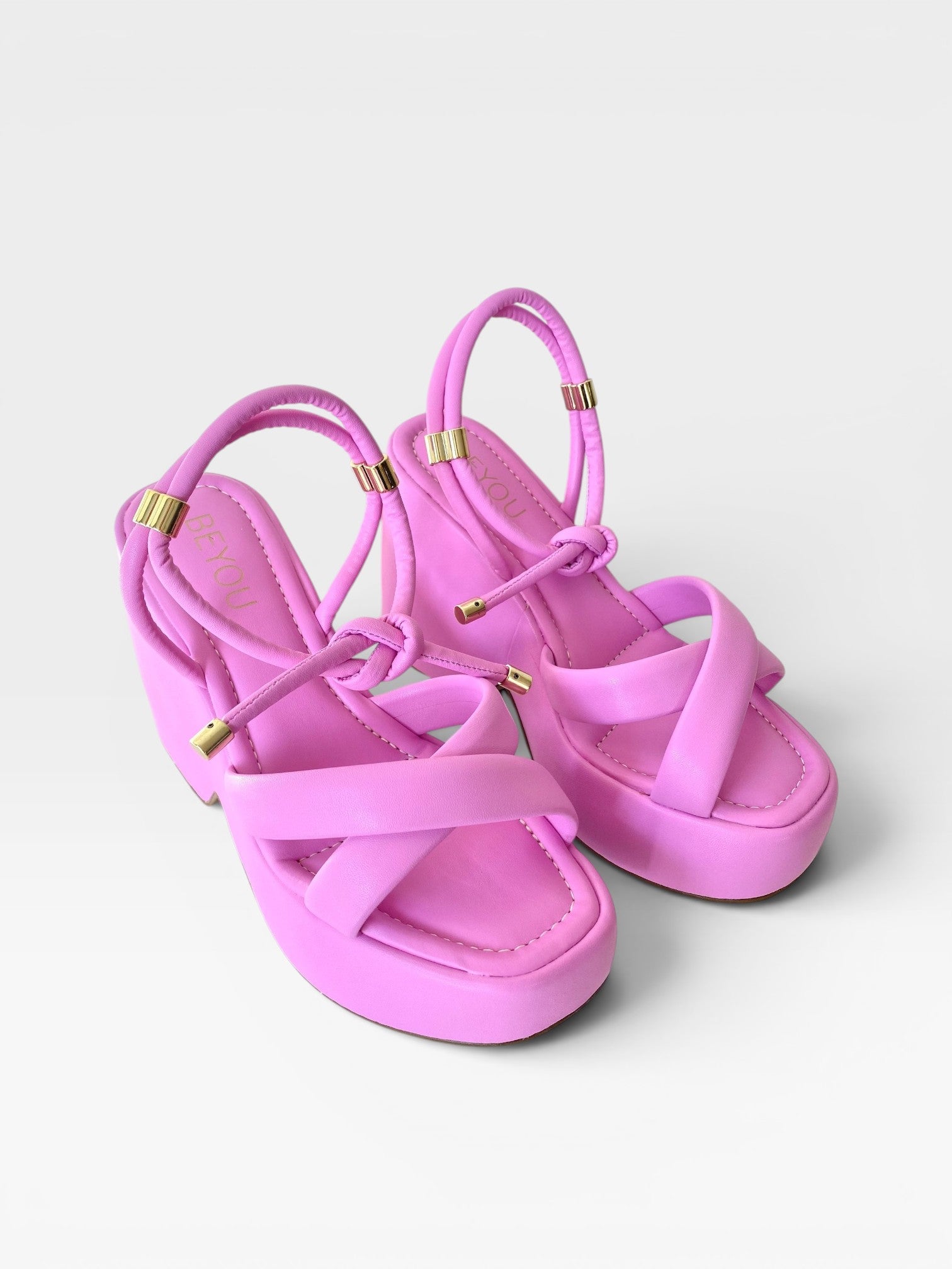 Sandália Mykonos Beyou Shoes rosa em napa com salto plataforma, tiras cruzadas e detalhes em metal dourado.