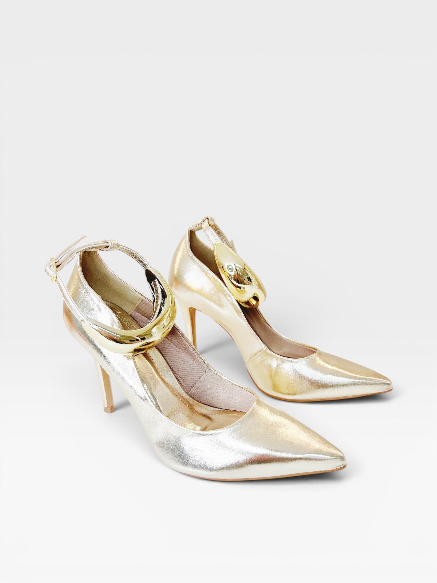 Scarpin Beyou Shoes Louvre na cor ouro light em napa com salto alto de 10 cm e detalhe metálico no tornozelo