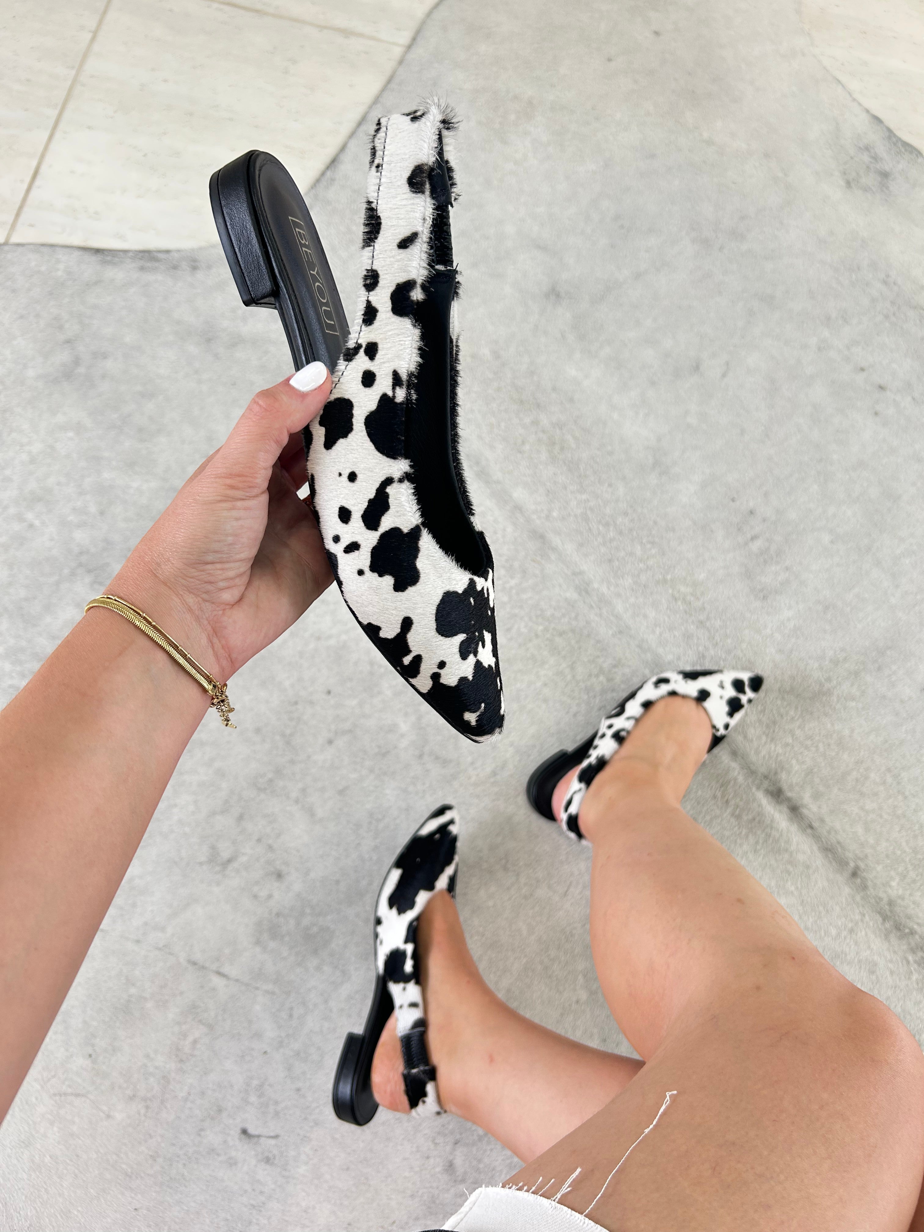 Slingback Beyou Shoes Barretos em couro com estampa animal print de vaquinha preta e branca, modelo sem salto.