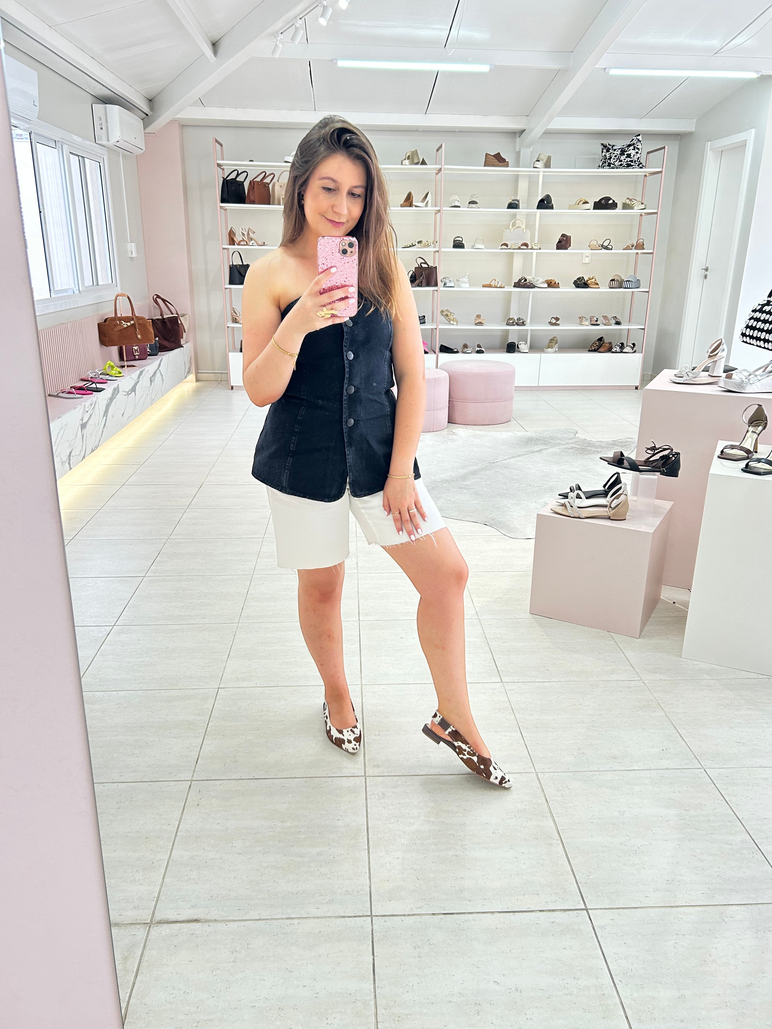 Mulher usando slingback Beyou Shoes de couro com estampa animal print de vaca em loja de calçados