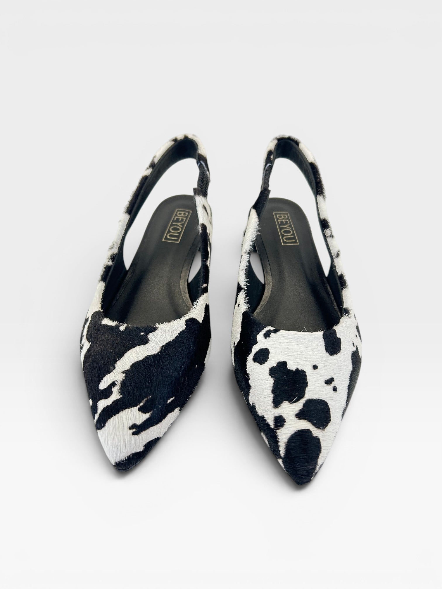 Slingback Beyou Shoes Barretos em couro com estampa animal print de vaca preta e branca e bico fino