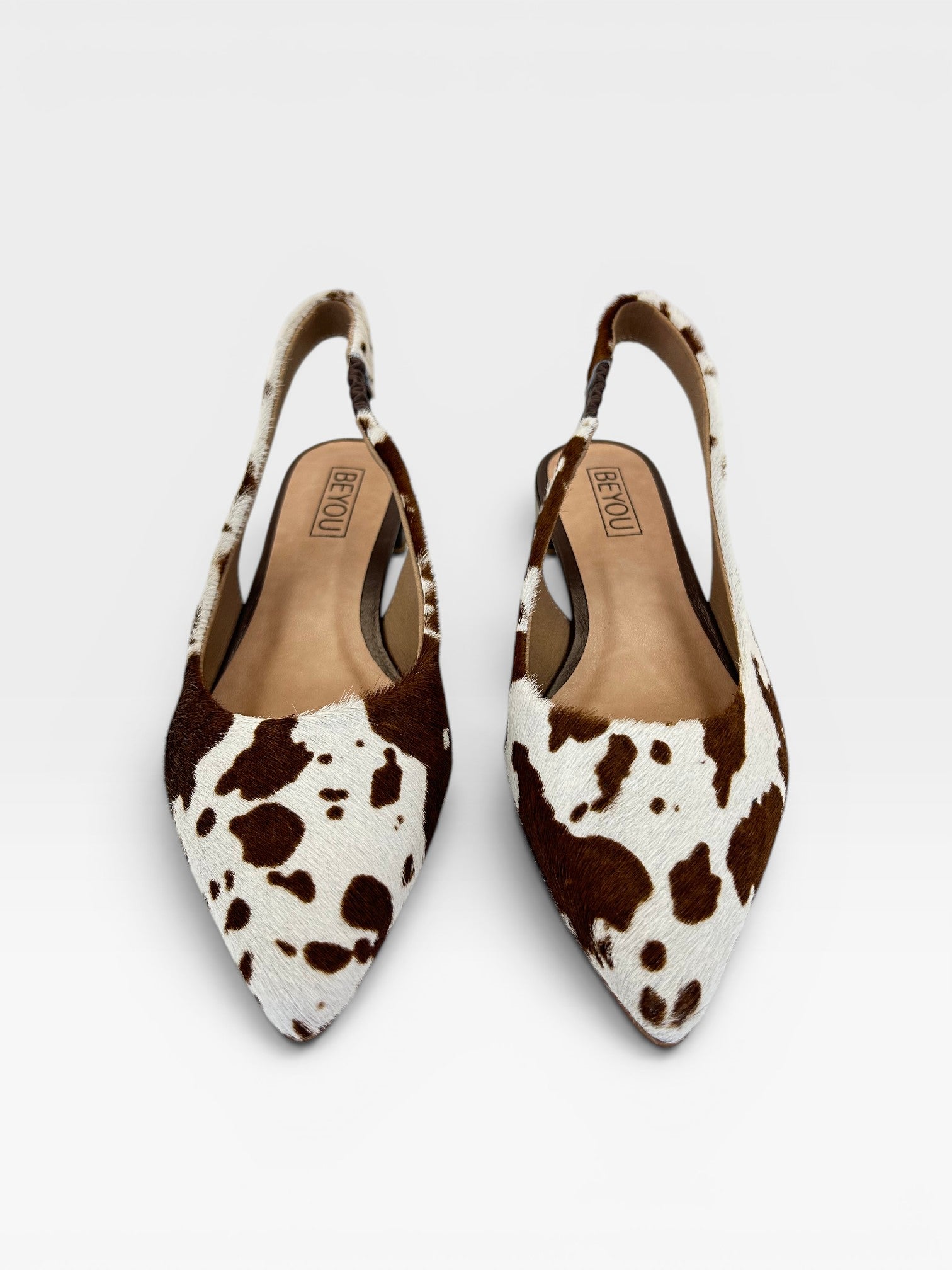 Slingback Beyou Shoes Barretos em couro legítimo com estampa animal print de vaquinha preta e marrom, bico fino.