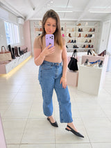 Mulher usando slingback Beyou Shoes preto de couro com bico fino em loja de calçados com prateleiras ao fundo