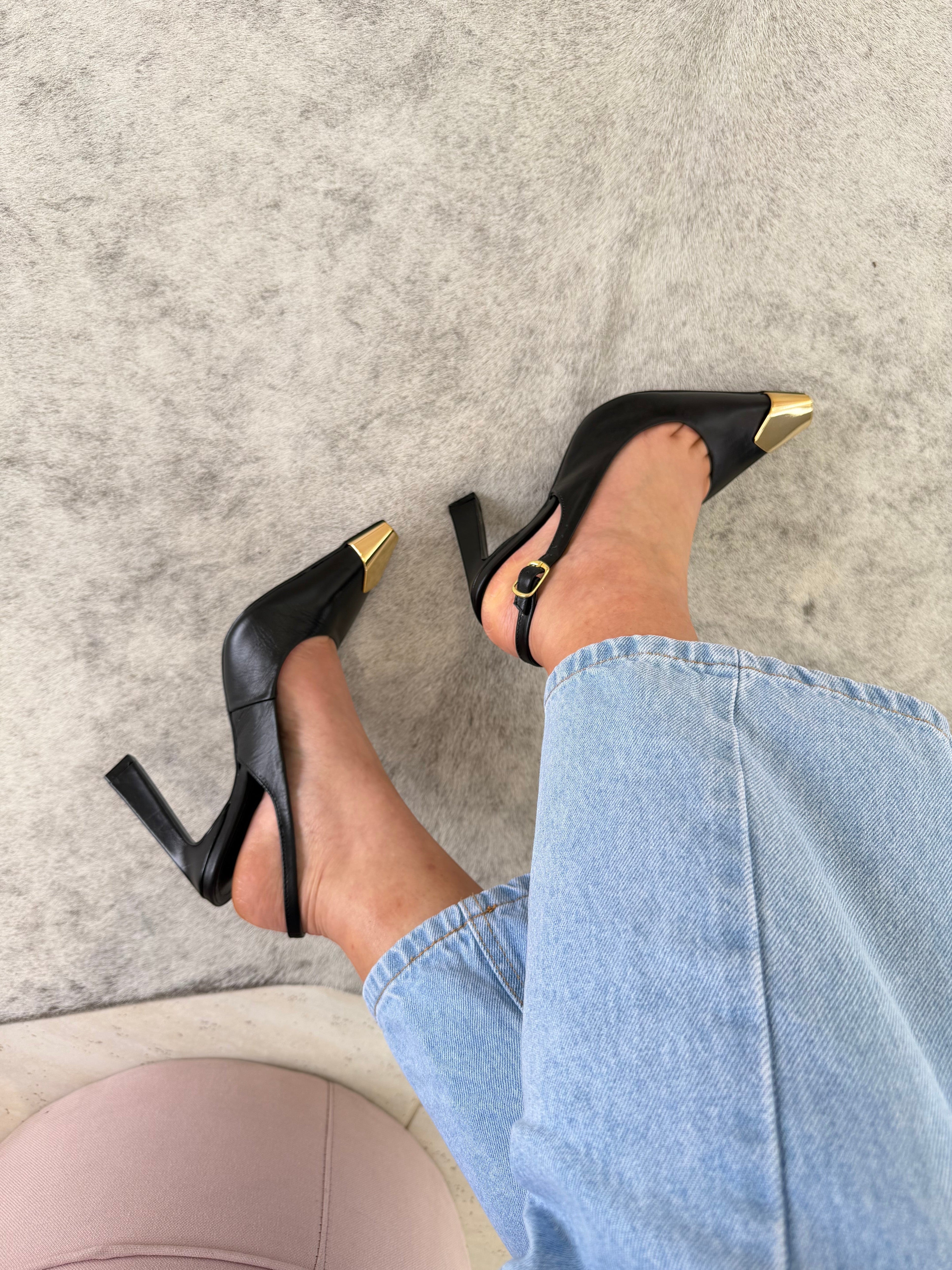 Slingback Beyou Shoes Bristol em couro preto com ponteira metálica dourada e salto alto, usado com calça jeans.