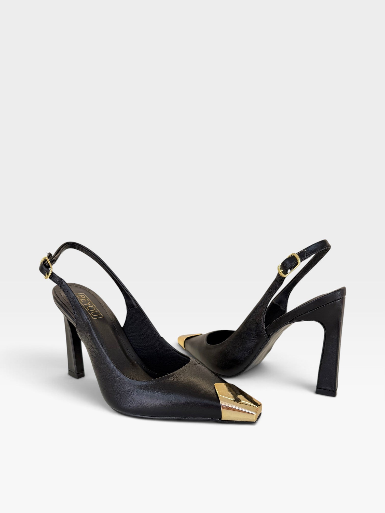 Slingback Beyou Shoes Bristol em couro preto com salto alto e ponteira metálica dourada