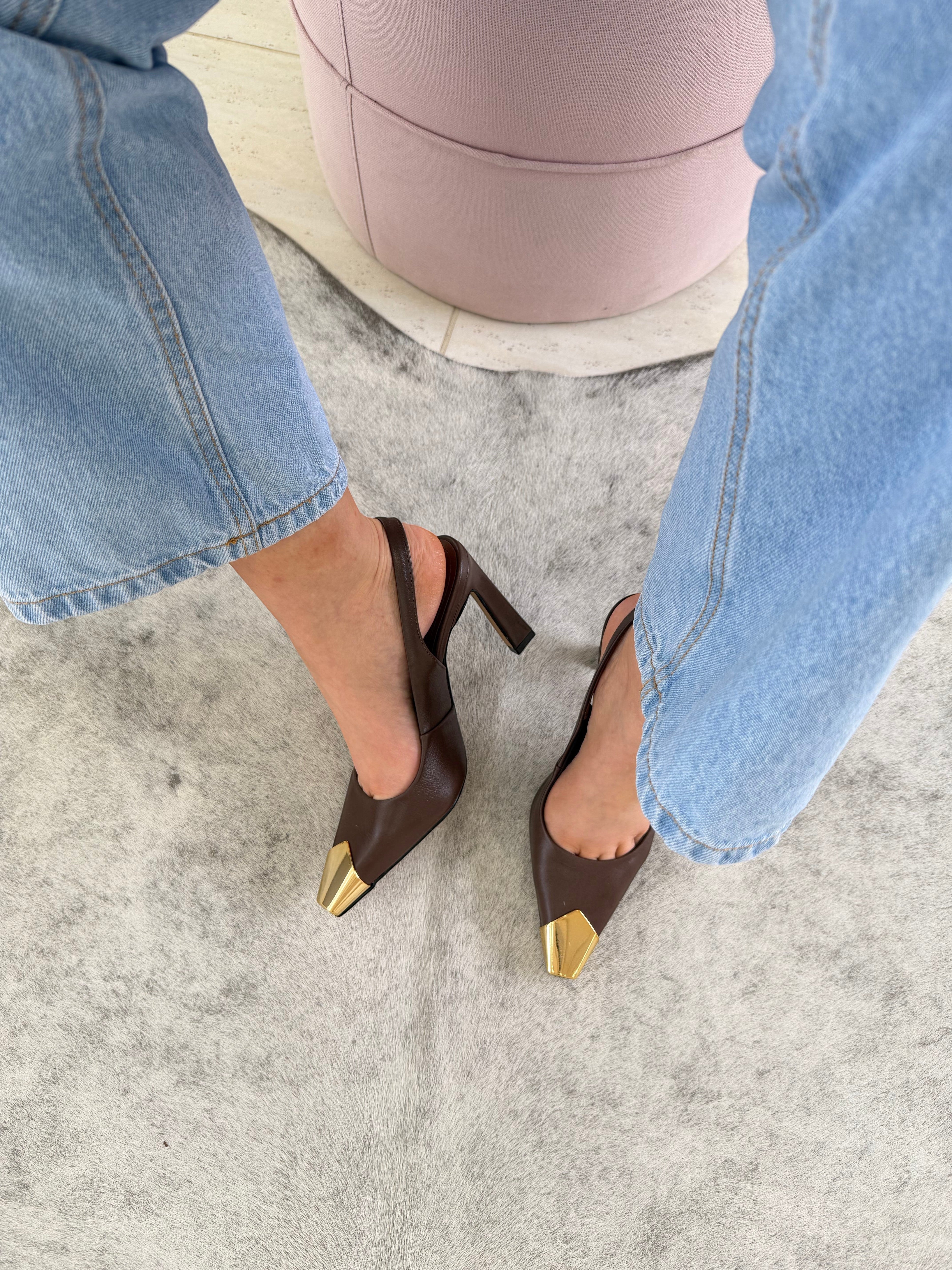 Slingback Beyou Shoes Bristol em couro marrom com ponteira metálica dourada, usado com calça jeans clara.
