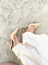 Slingback Beyou Shoes off white em couro com bico fino e salto taça, calçado nos pés com calça branca