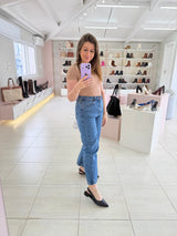 Mulher usando slingback Beyou Shoes preto de couro com bico fino em loja de calçados com prateleiras ao fundo
