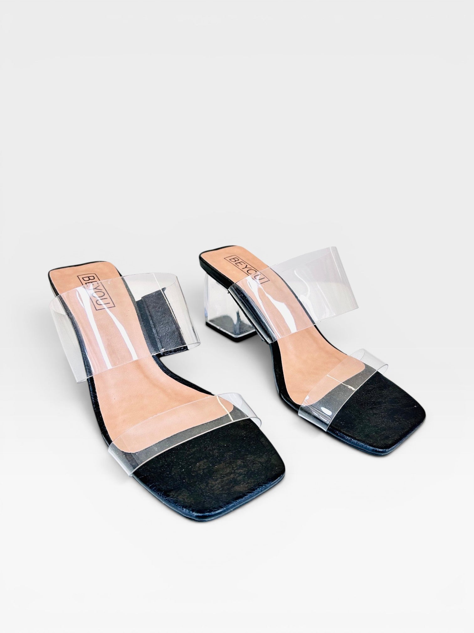 Tamanco Lisboa Black Beyou Shoes com tiras transparentes, palmilha preta e salto bloco transparente de 7,5 cm.