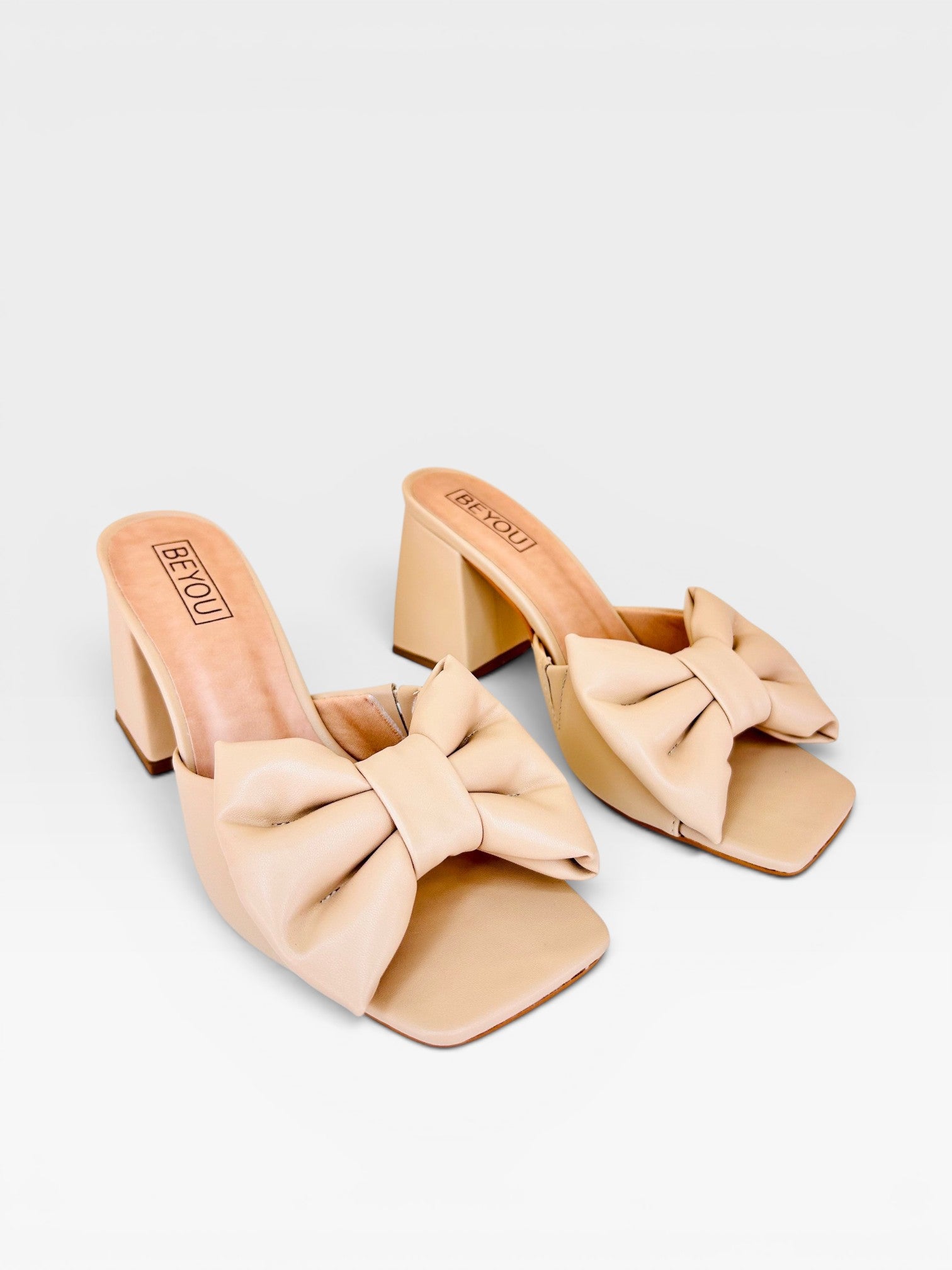 Tamanco Napoli Beyou Shoes nude em napa com salto bloco de 8,5 cm e detalhe de laço frontal elegante.