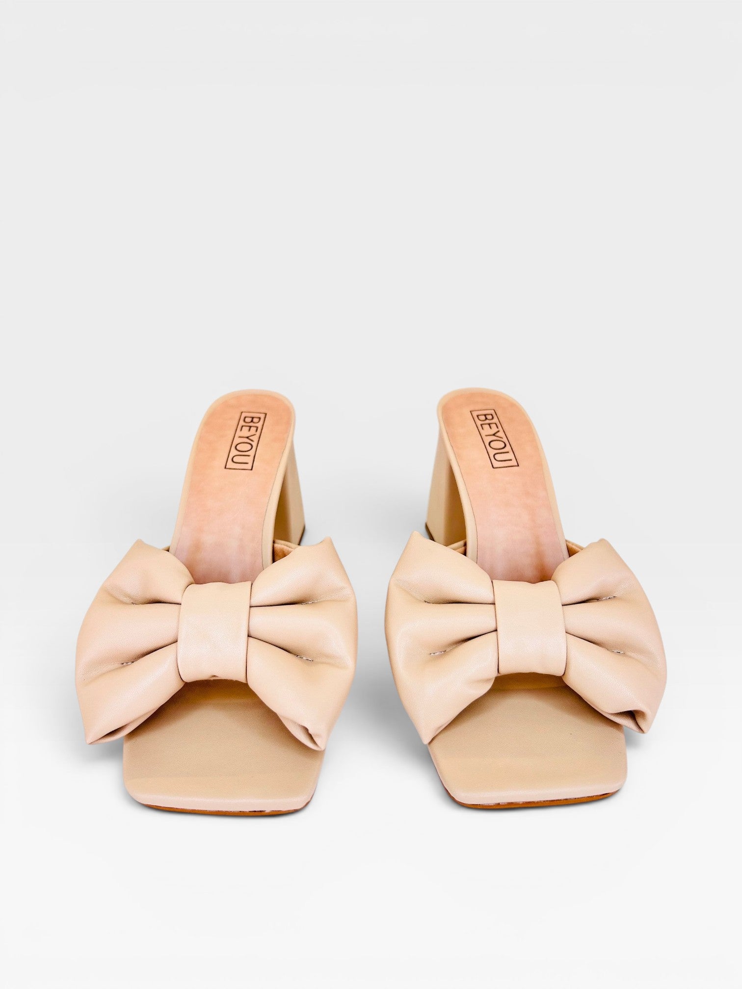 Tamanco Beyou Shoes Napoli na cor nude, feito em napa com laço frontal e salto bloco de 8,5 cm.