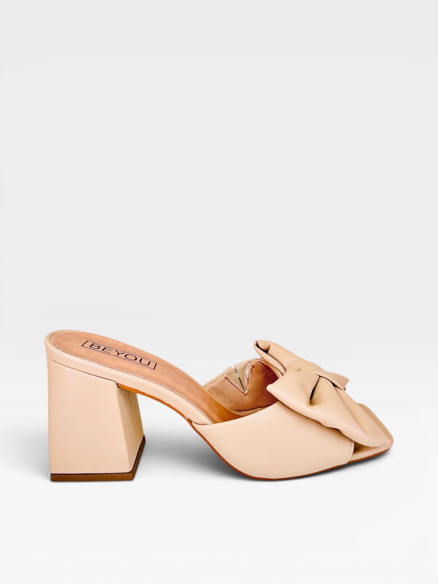Tamanco Beyou Shoes Napoli na cor nude, feito em napa com salto bloco de 8,5 cm e detalhe de laço frontal elegante.