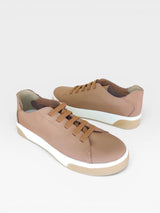 Tênis Berlin Beyou Shoes em couro caramelo com cadarços no mesmo tom e solado flat branco, design urbano e moderno.