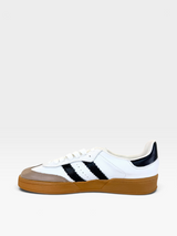 Tênis Beyou Shoes Brazil em couro branco com listras pretas e solado de borracha caramelo, vista lateral.
