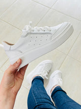 Tênis Beyou Shoes Chicago branco em couro com solado plataforma, segurado por uma mão sobre fundo claro.