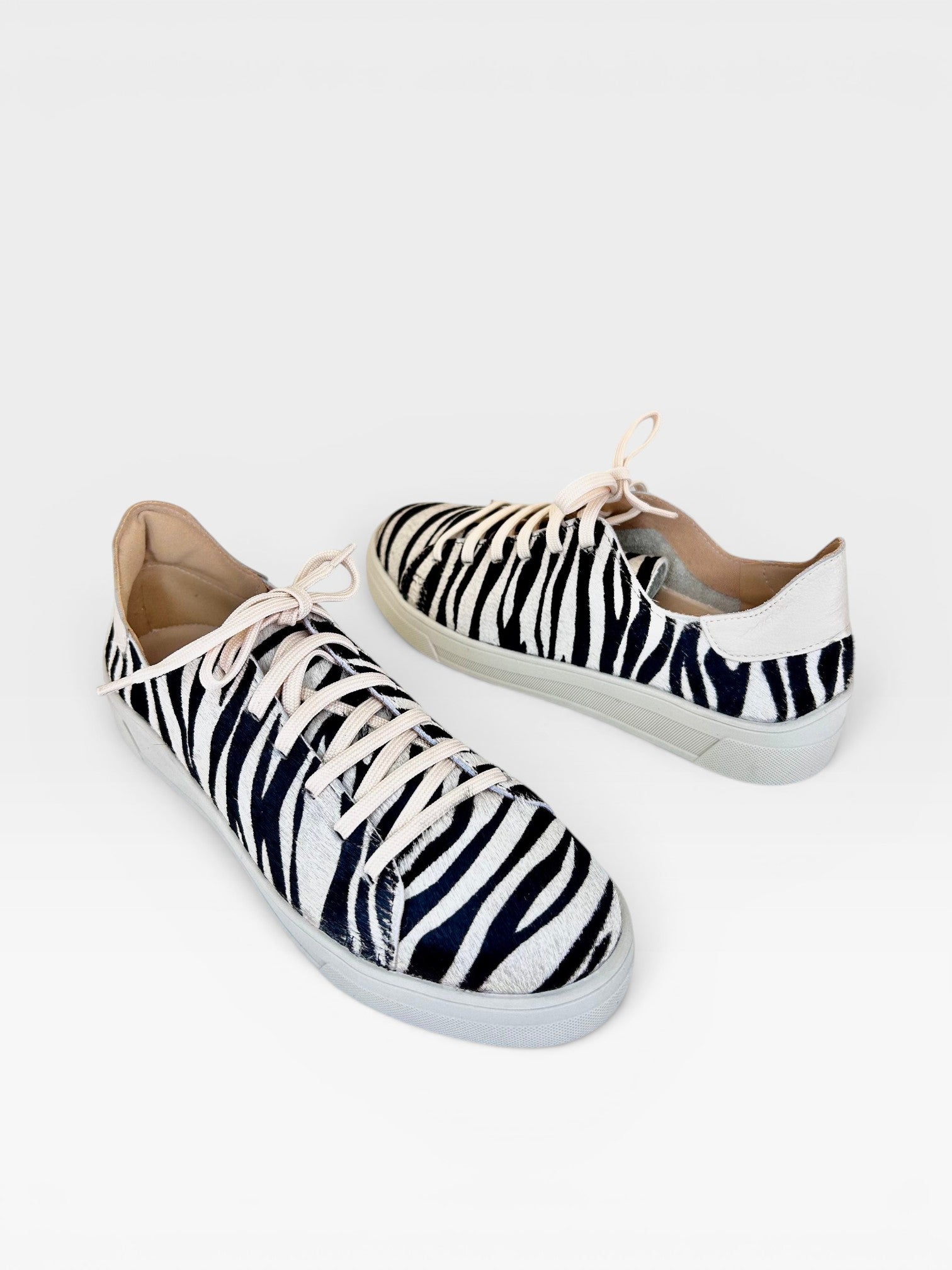 Tênis Beyou Shoes Savannah em couro com estampa animal print de zebra, cadarços claros e solado baixo.