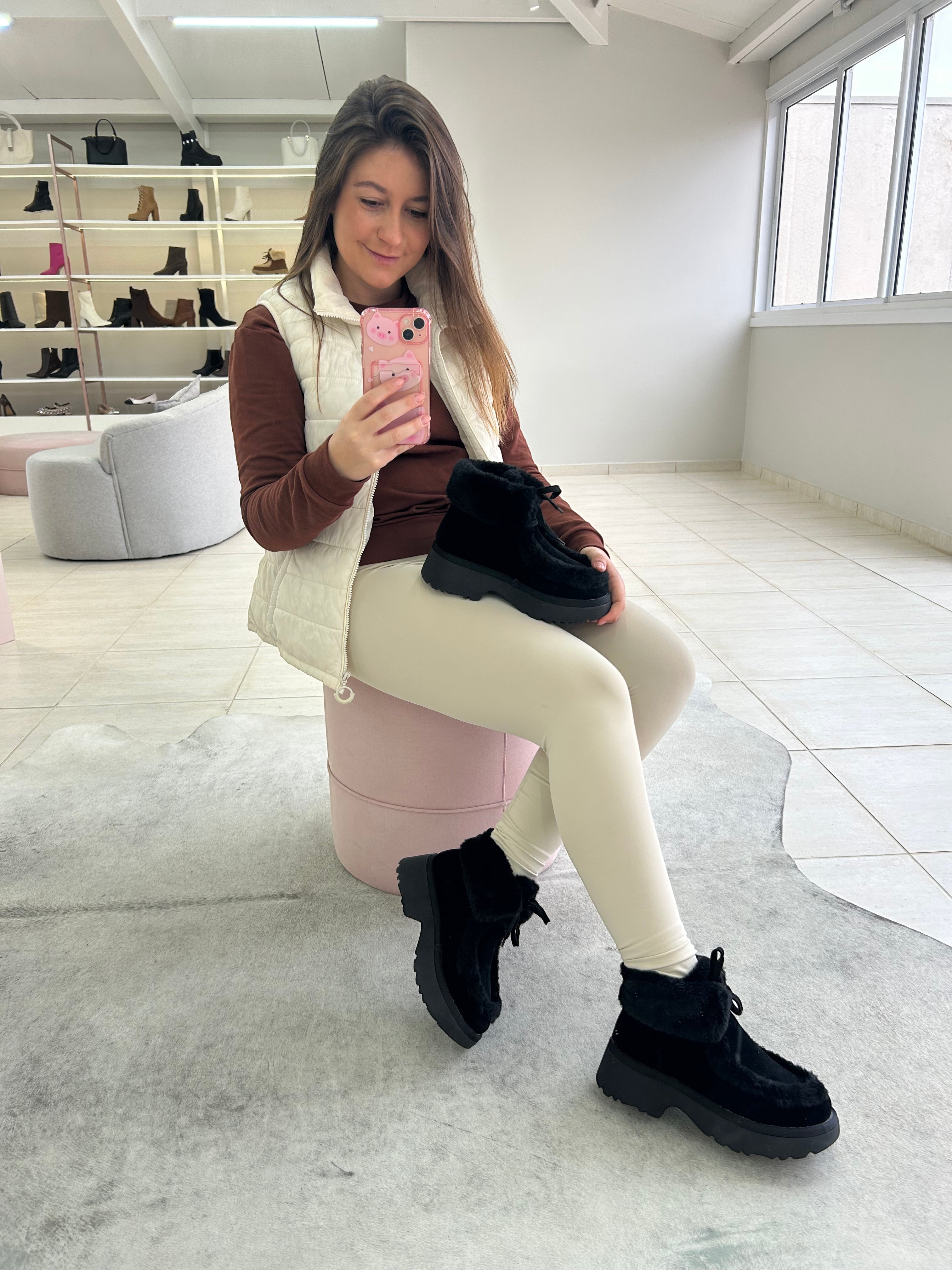 Mulher usando tênis Beyou Shoes Helsinque preto de camurça sintética com forro de pelinhos em ambiente de loja.