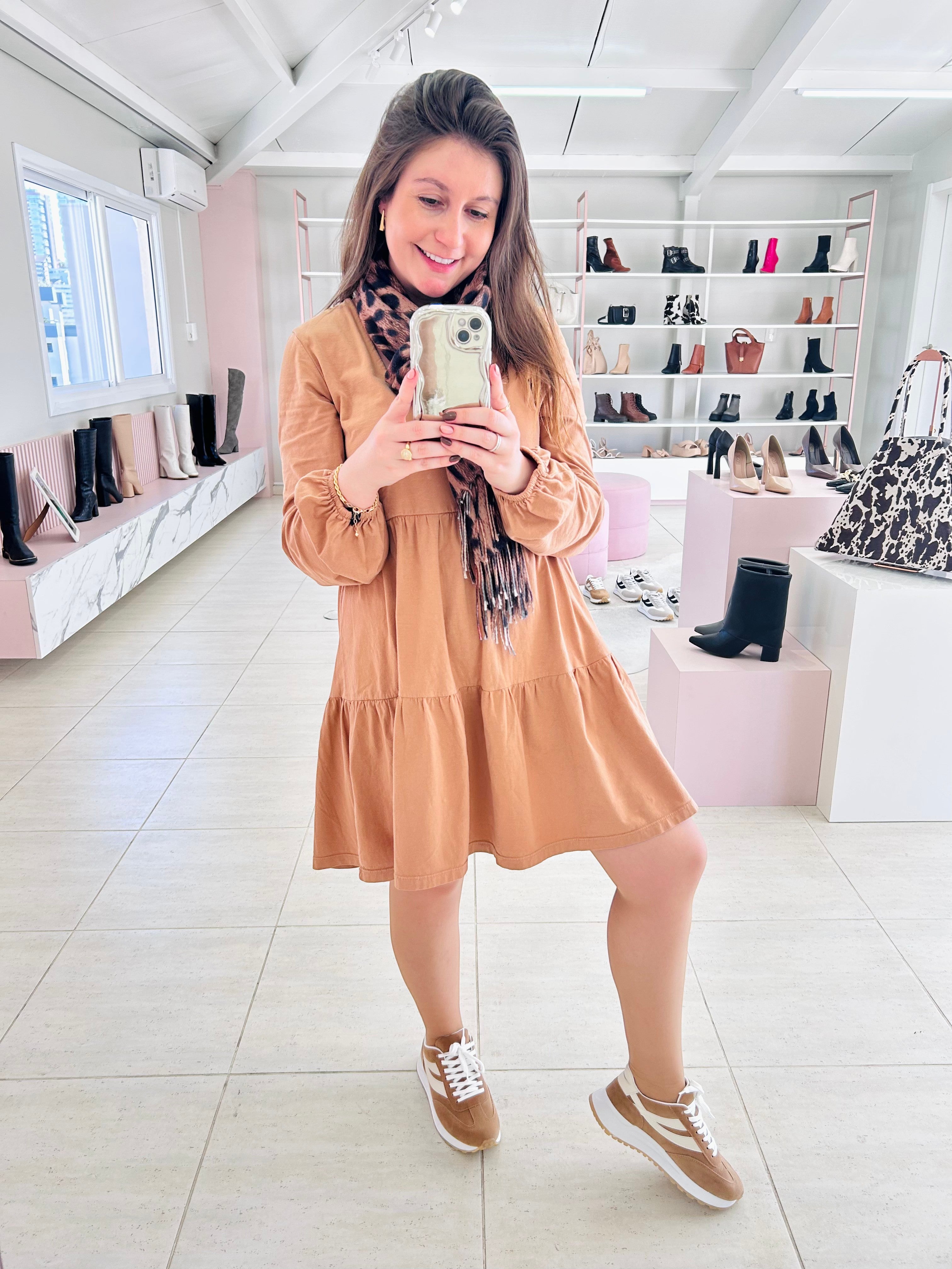 Mulher usando tênis Beyou Shoes Oslo bege de tecido e camurça sintética em loja de calçados com vestido casual