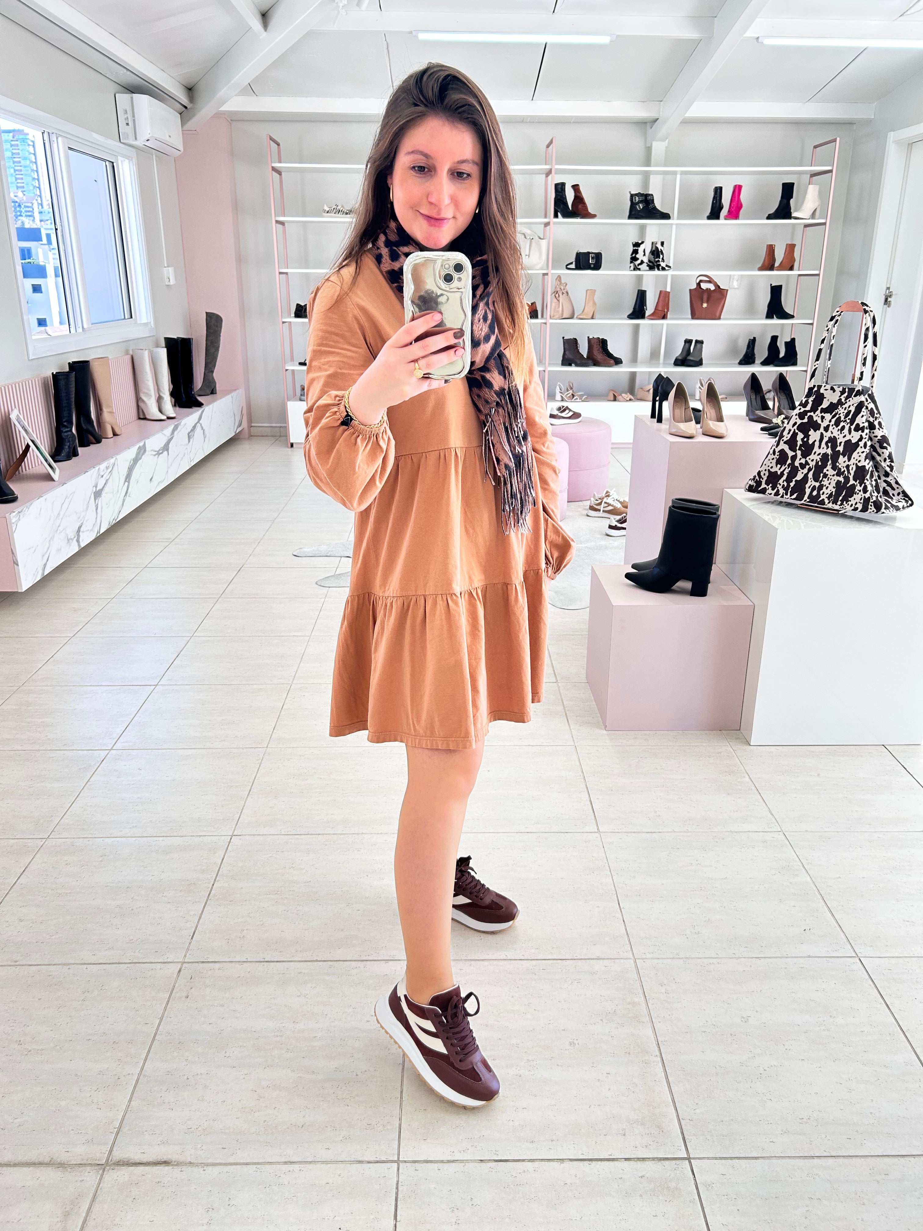 Mulher usando tênis Beyou Shoes Oslo marrom com detalhes em tecido e camurça sintética em loja de calçados.