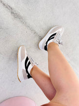 Tênis Beyou Shoes Oslo off white com detalhes em camurça sintética e solado esportivo, calçado no pé de uma modelo.